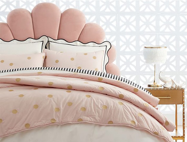 bed with pink polka-dot sheets and a statement headboard