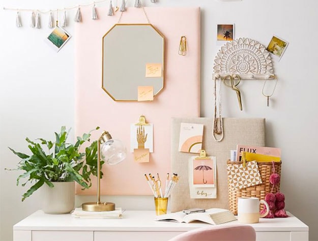 white desk with hanging mirror and pinboard