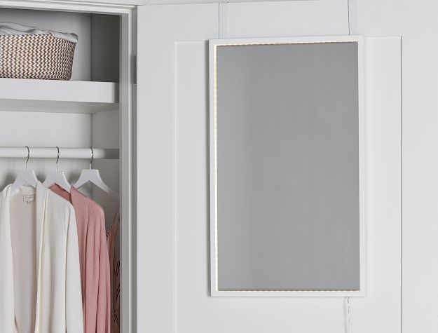 LED-lit mirror hanging on open closet door