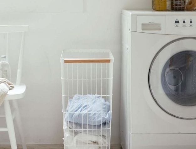 laundry basket next to washing machine