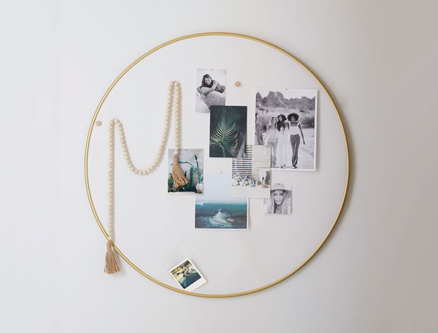 Round gold metal pinboard on a wall with photos