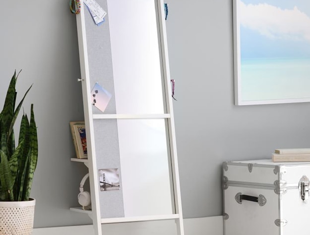 Leaning mirror and pinboard against gray wall