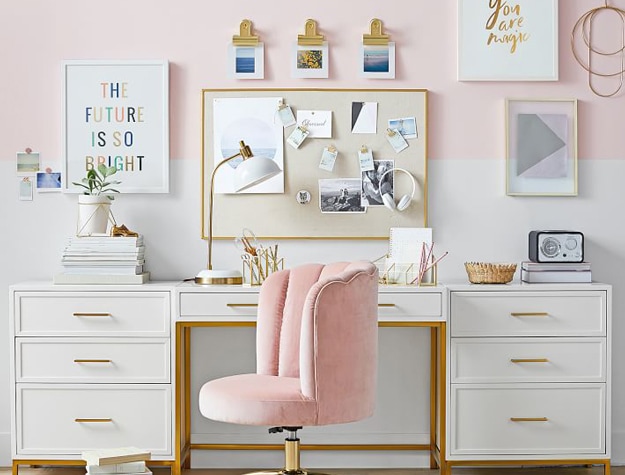 White desk and pink chair with photo board and framed images hanging above