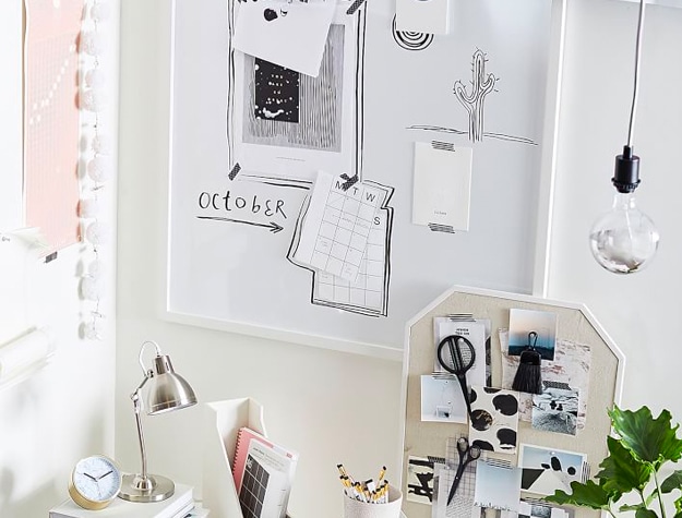Dry erase board with notes above desk and lamp