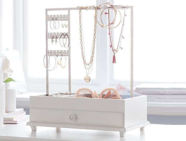White jewelry stand with drawer on table