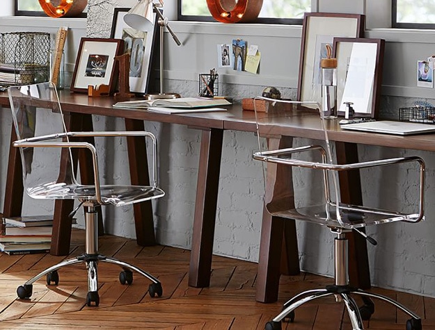 Paige acrylic silver swivel desk chairs at desks.