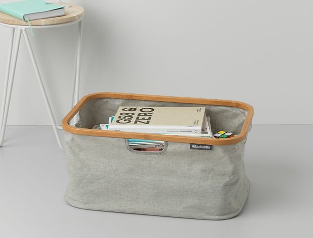 Foldable laundry basket holding books.