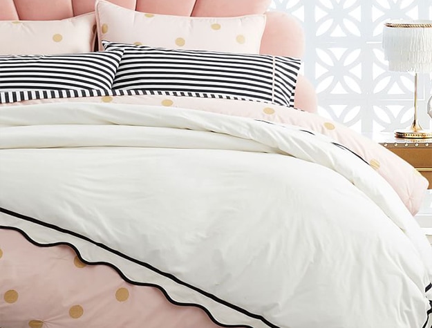 Pink polka dot duvet with black and white striped bedding set.