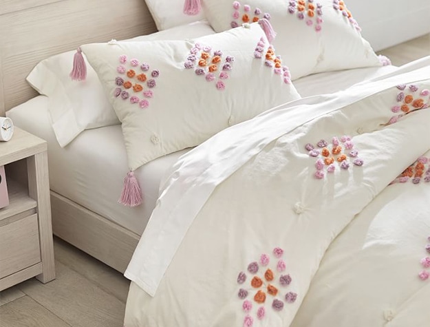 Bohemian duvet set with pink, orange and purple tassels and pom-poms.
