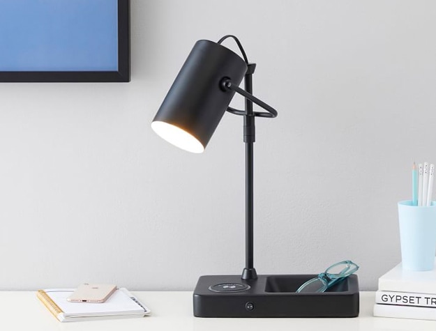 Catchall Wireless spotlight lamp with USB on a desk with glasses, notepad, phone and stack of books.