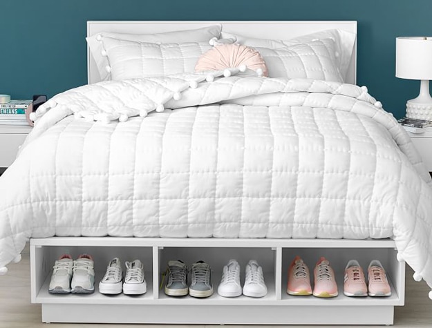 White Bowen storage bed organized with tennis shoes in the under-mattress storage cubbies.