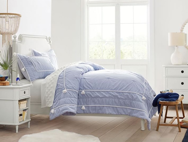 Colette classic bed styled with a light blue comforter in a bright and airy bedroom.