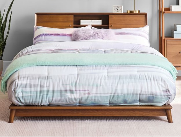 west elm x pbt Mid-Century Headboard storage platform bed in acorn styled with a purple and turquoise striped comforter.