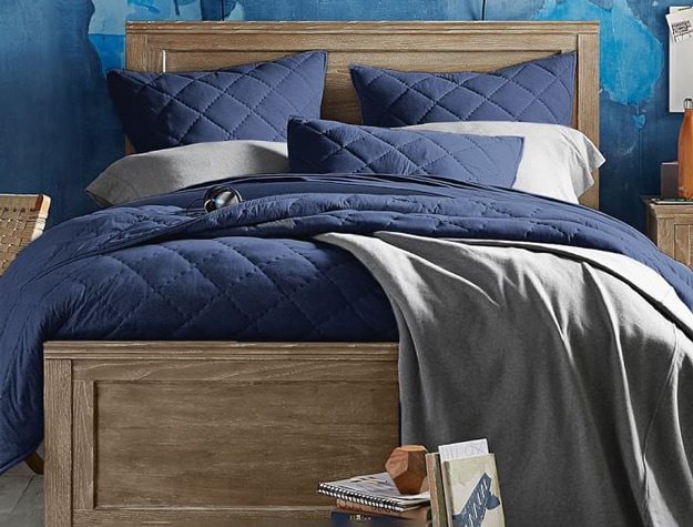 Hampton classic bed in smoked gray styled with a navy comforter and gray sheets.