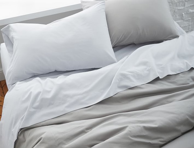 A gray Super Soft Cotton Sateen Duvet Cover styled with crisp white sheets and a matching gray pillow sham.