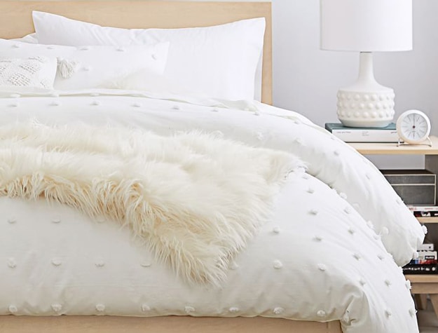 Tufted Dot Duvet Cover in white styled with white sheets and a matching pillow sham. 
