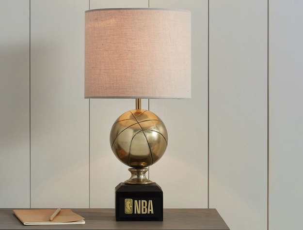 a basketball-themed lamp sitting on a desk next to a notebook and pen