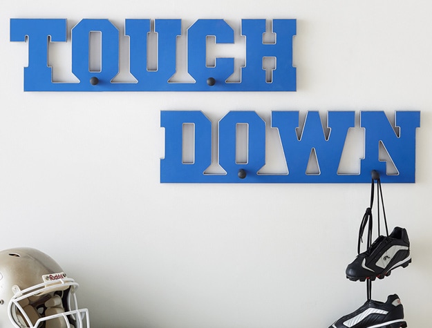 football cleats dangling from a wall hook organizer that says touchdown