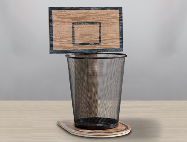 a trash can in front of a wooden block resembling a backboard