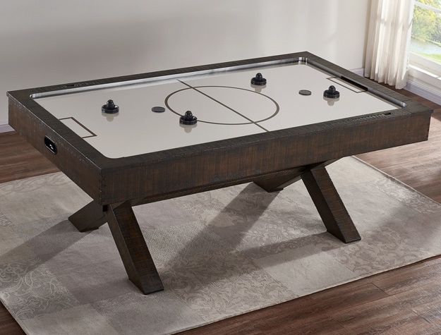 an air hockey table placed by a window in front of two paintings