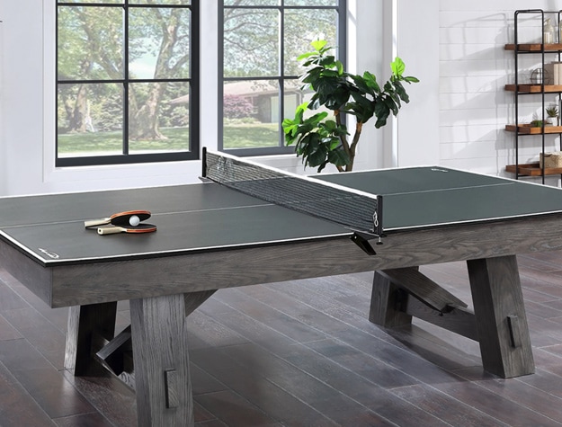 a table tennis convertor laid on top of a table in an open room