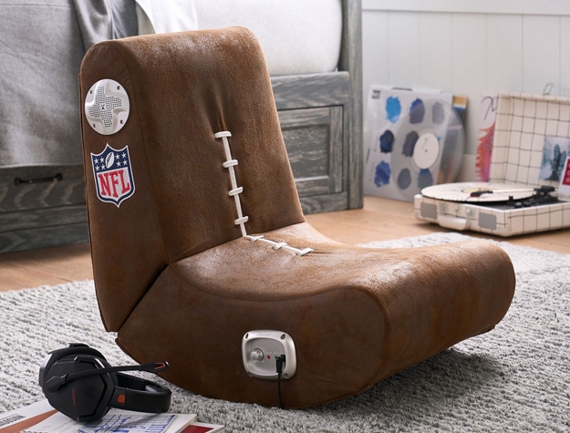 An NFL-themed rocking chair on a gray rug in a teenager’s room