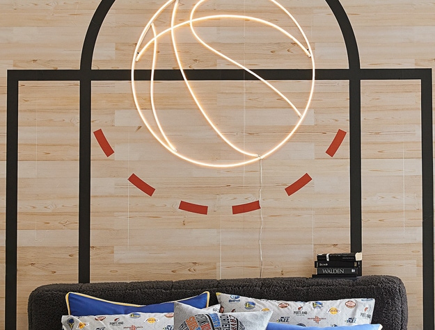 a basketball decal displayed over a bed with NBA pillows
