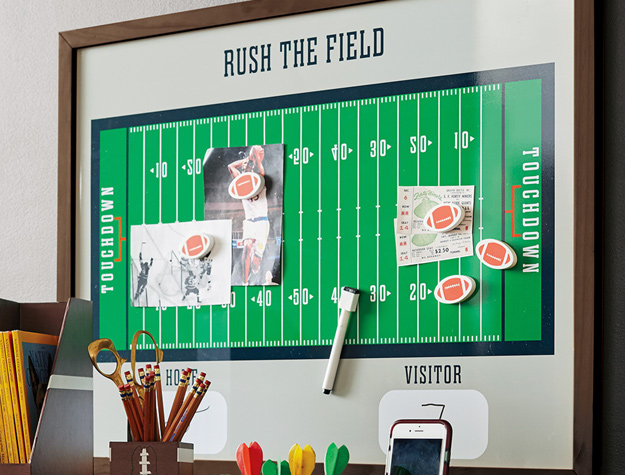 A magnet wall resembling a football field holding pictures of athletes and ticket stubs
