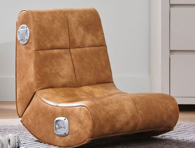 A small leather rocker chair sitting in a bedroom.