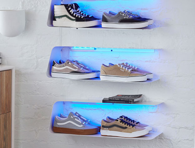 A wall shelf with shoes lit up by LED lights.