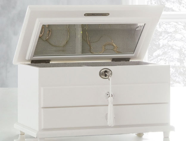 White jewelry box with gold earrings inside.