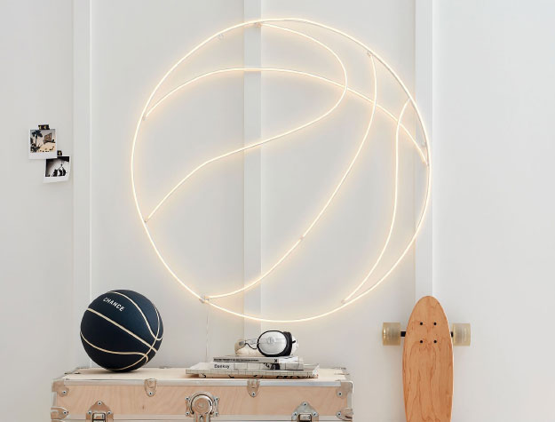 A large LED basketball light hanging on the wall of a bedroom.