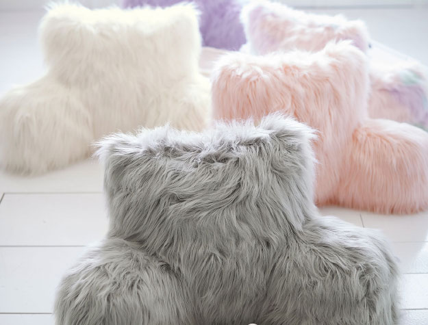 Five faux-fur backrest pillows in a sunny room.