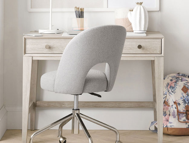 A personal desk with a rolling desk chair placed in front.