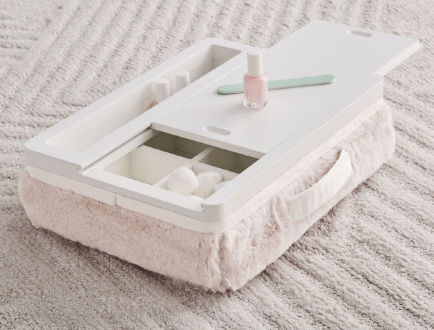 A white mani-pedi lapdesk sitting on a carpet.
