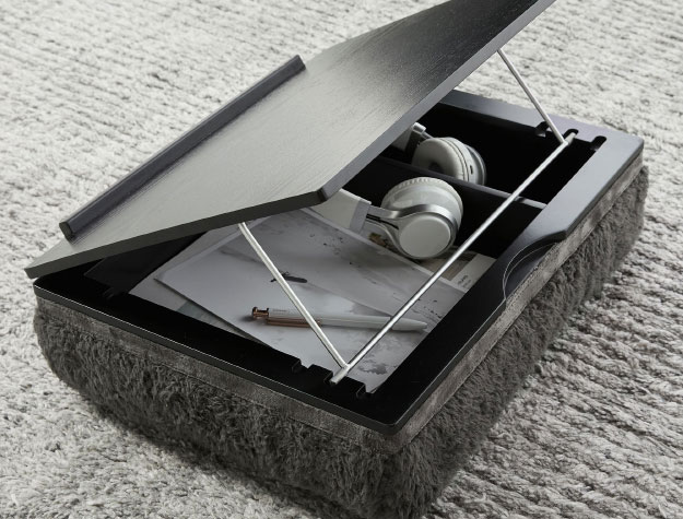 A black lapdesk sitting on a carpet.