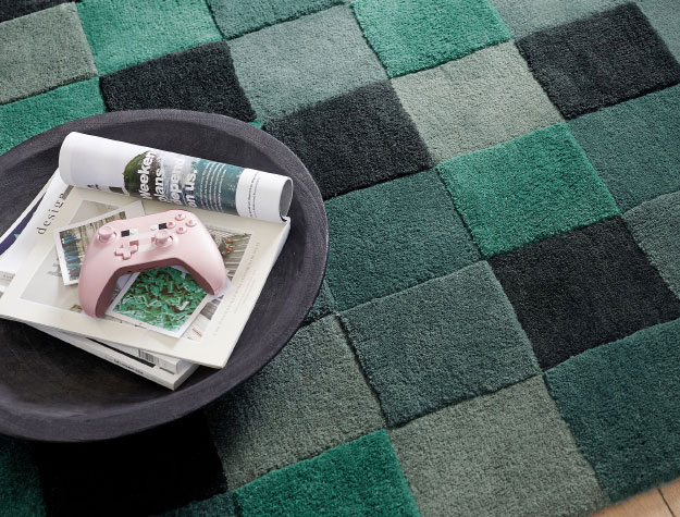 A green and black Minecraft rug on the floor.