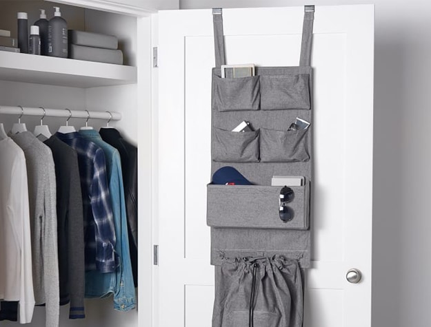 Gray hamper organizer hanging on open closet door