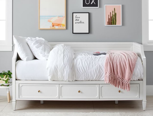 White Auburn daybed with storage drawers, styled with a white comforter and pillows. 