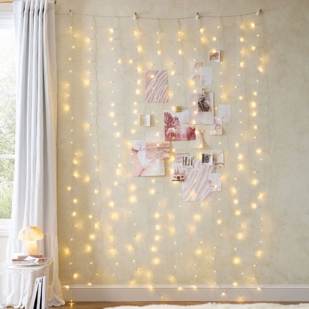 Hanging fairy lights on wall in room 