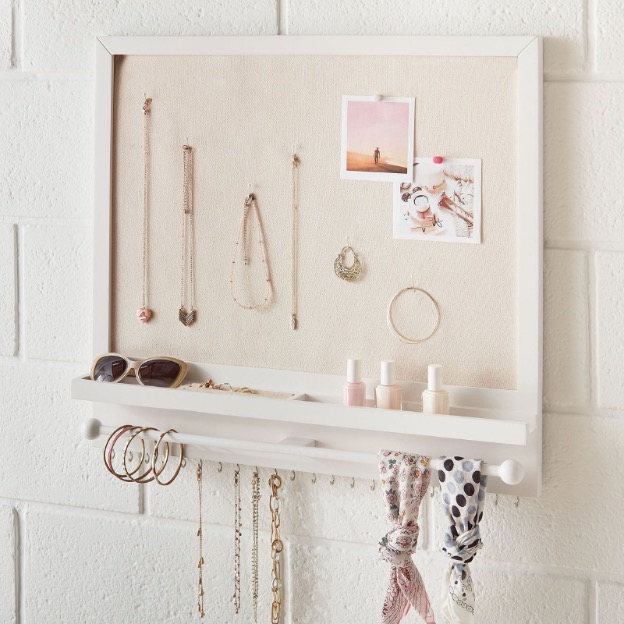 Pinboard in a college dorm holding jewelry, accessories and photos 