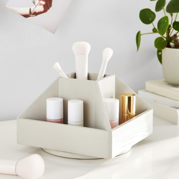 White beauty organizer holding makeup products, brushes and nail polish.