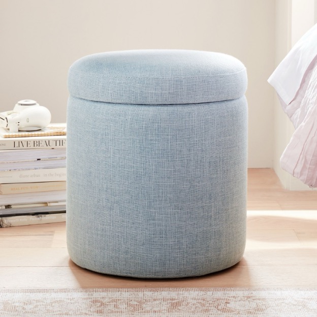 This light blue round storage ottoman features a convenient lid for easy access to the things stored inside.