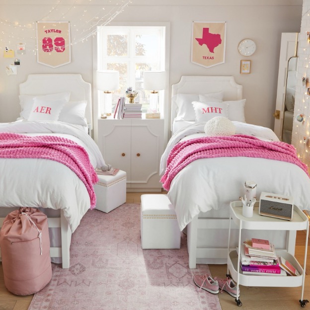 Two cozy pink throw blankets are shown styled on matching white twin XL dorm beds