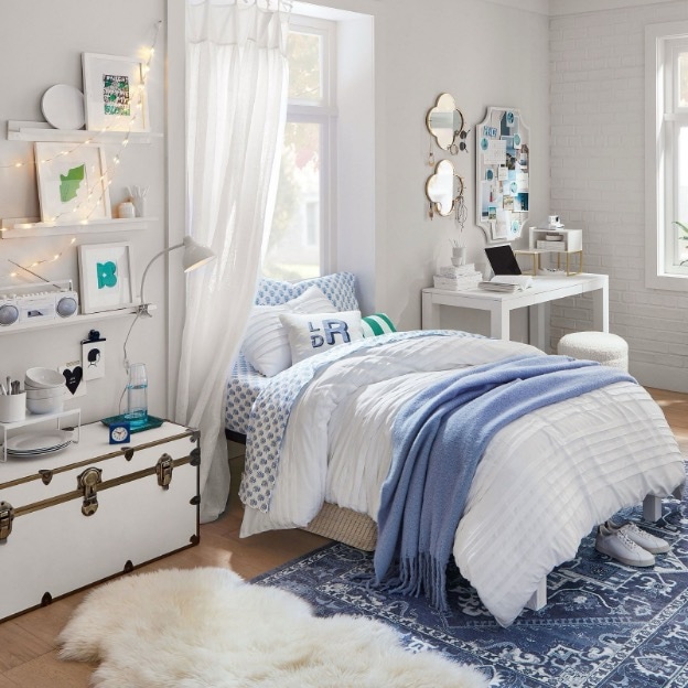 A blue-and-white washable rug grounds this preppy-chic dorm bedroom