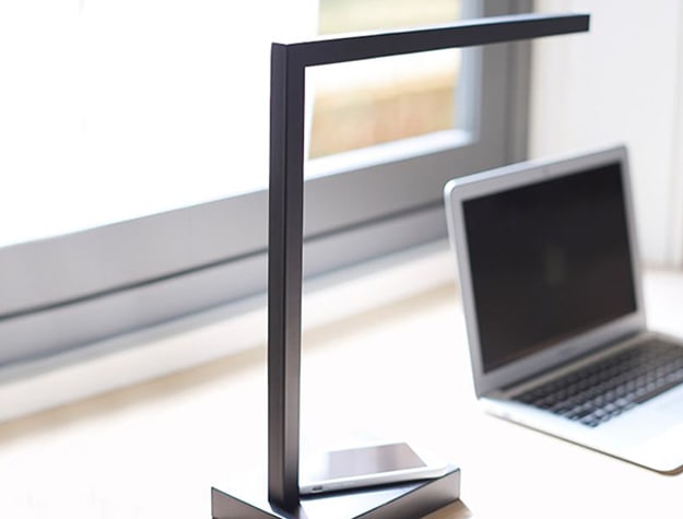 Greene charge led task lamp with charging phone on base.