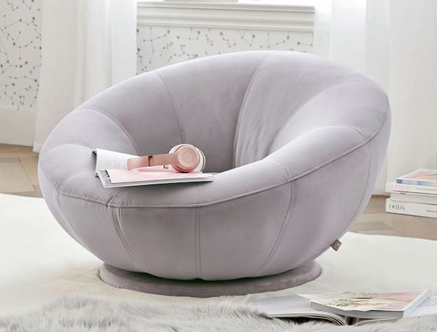 Performance everyday velvet gray groovy swivel chair with book and headphones.