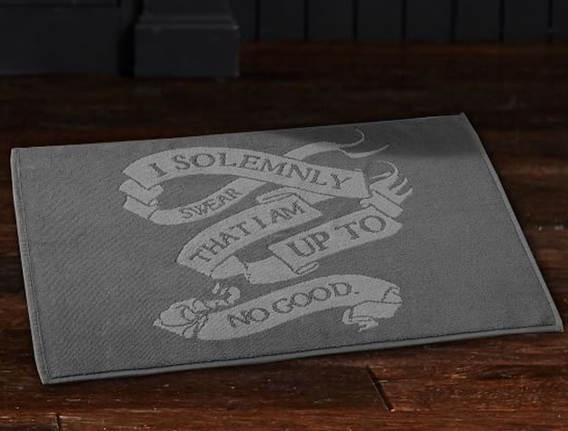 A bath mat that reads, “I solemnly swear I am up to no good” rests on the floor.