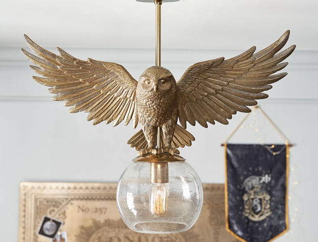 A light pendant features Hedwig sitting atop a glass orb.