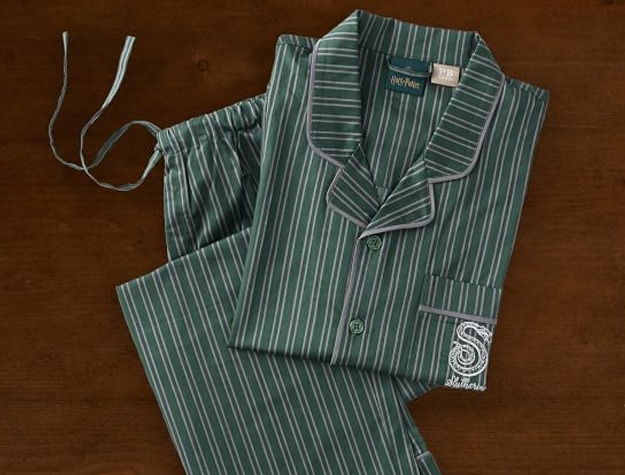 A pajama set inspired by Harry Potter’s Slytherin House rests on a wooden backdrop.